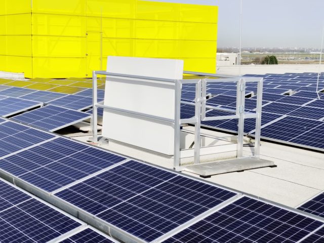 Hekwerken tussen de zonnepanelen op het dak voor veiligheid en afscherming.